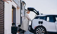 kobieta pakująca bagaż do samochodu elektrycznego